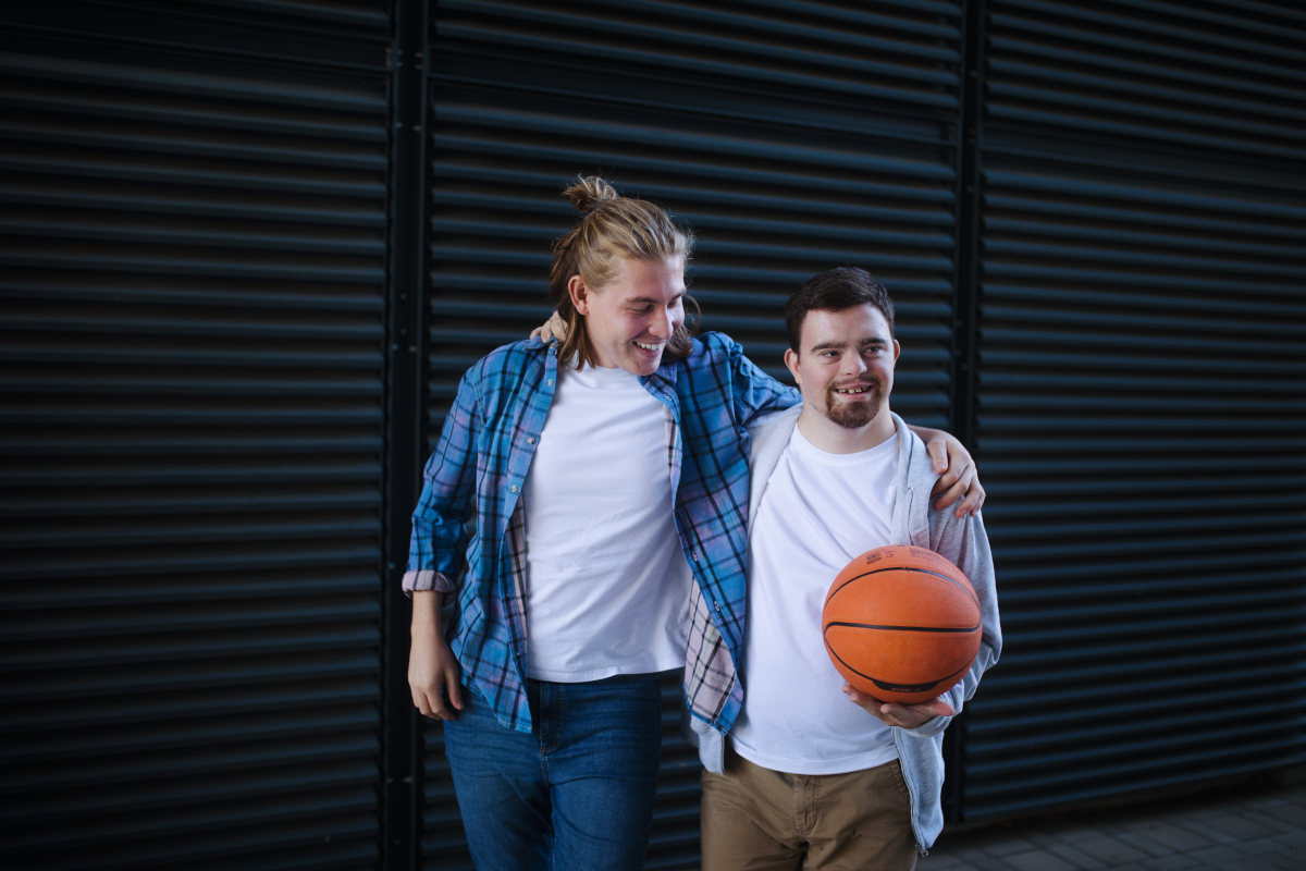 two people holding shoulders, and one holding a basket ball