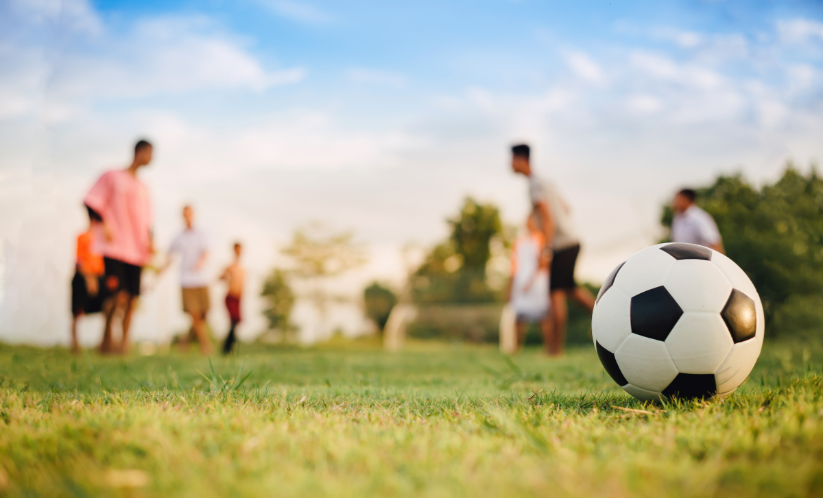 soccer ball on grass with people in the background